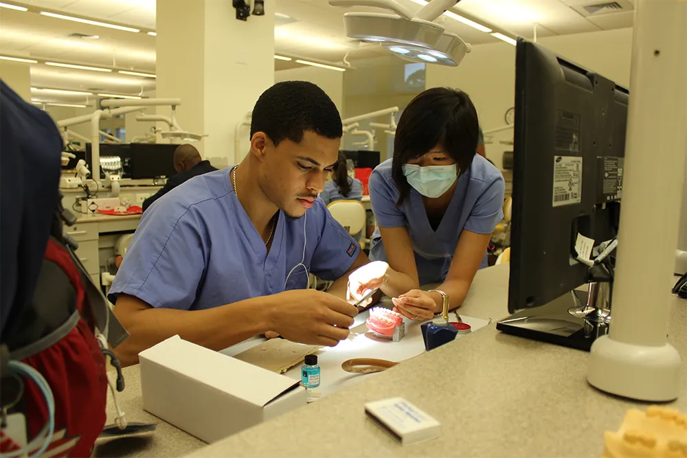 a man and a woman in scrubs sitting at a desk
