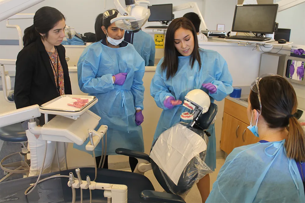 a group of women standing around a dentist chair