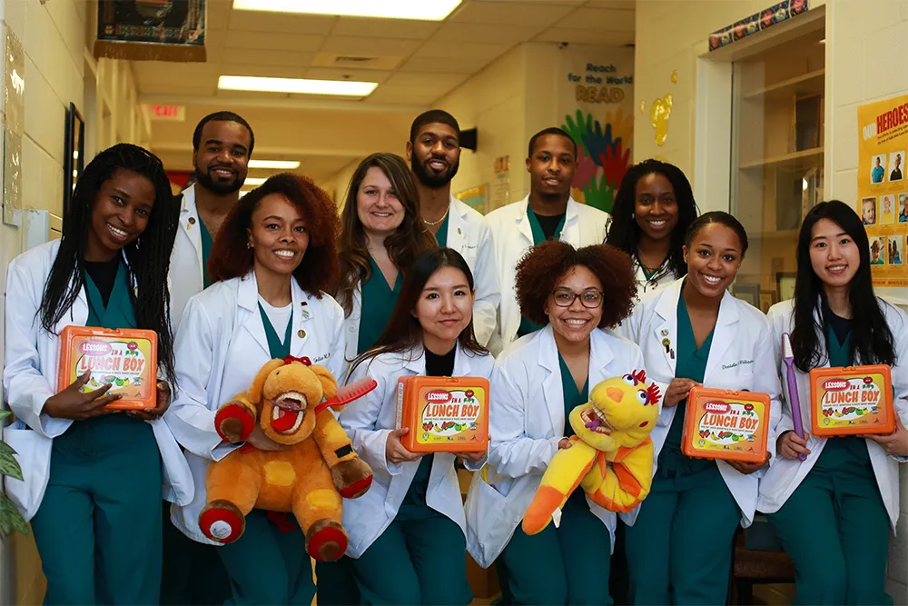 a group of people in white lab coats holding stuffed animals